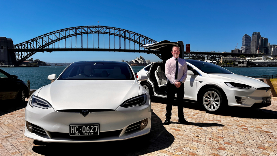 Richard standing between a white Tesla Model S & white Tesla Model X.
